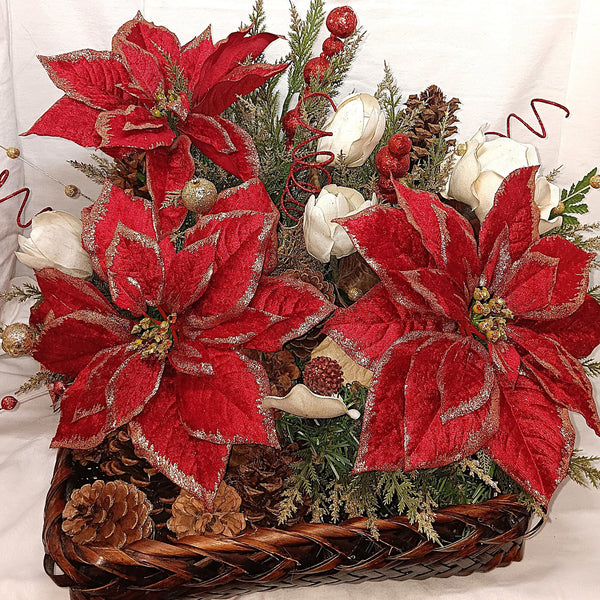 Decorative Christmas arrangement with red poinsettias, pinecones, and greenery, arranged in a large serving basket.