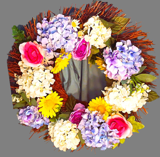 Colorful spring flowers include artificial Hydrangea, Roses, and Daisies on a grapevine wreath.  24"